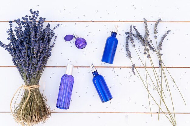 Flores de lavanda e óleo e produtos de lavanda em garrafas azuis