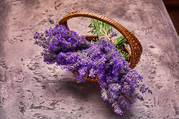 Flores de lavanda em uma cesta em fundo cinza de concreto. vista do topo.