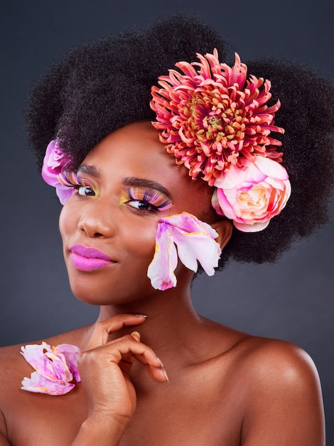 Flores de maquiagem e sorriso com retrato de mulher negra para beleza criativa e primavera Cosméticos naturais e florais com rosto de modelo isolado no fundo do estúdio para arte amor próprio ou confiança