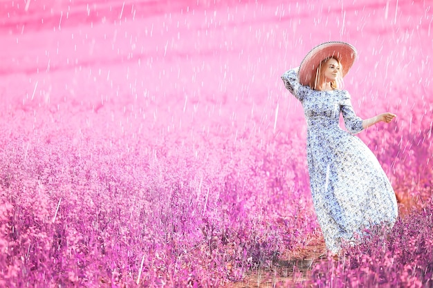 Flores de menina de campo de chuva de verão, bela jovem no campo de primavera com flores felicidade liberdade