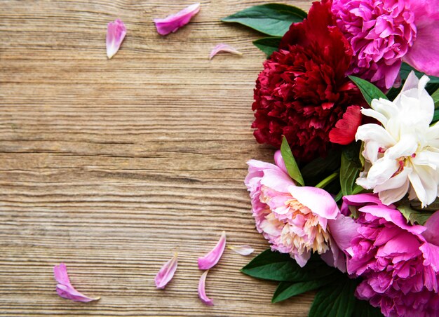 Flores de peônia rosa em uma velha mesa de madeira