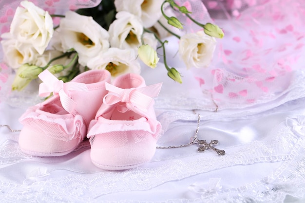 Flores de sapato de bebé e cruz para o batismo