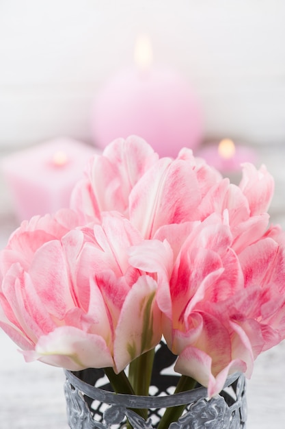 Flores de tulipa rosa fresca e velas acesas