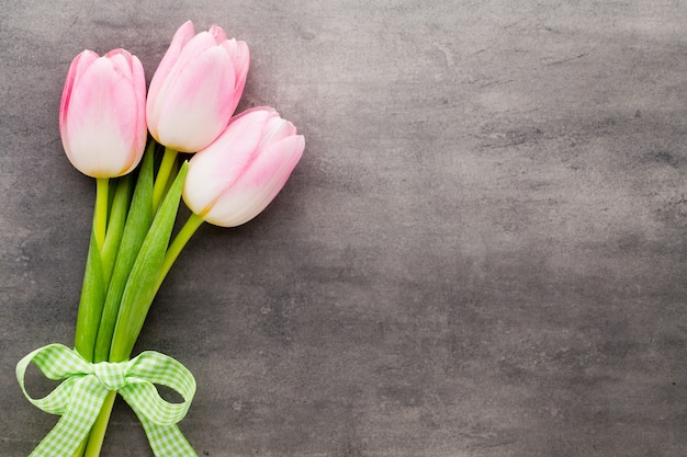 Flores de tulipa rosa na superfície cinza