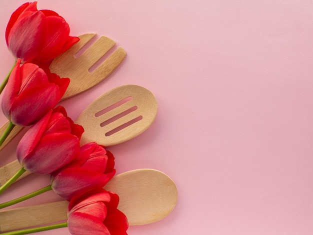 Flores de tulipas com utensílios de cozinha em fundo com espaço de cópia