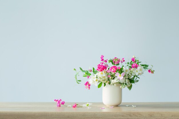 Flores de verão em copo de cerâmica na luz de fundo