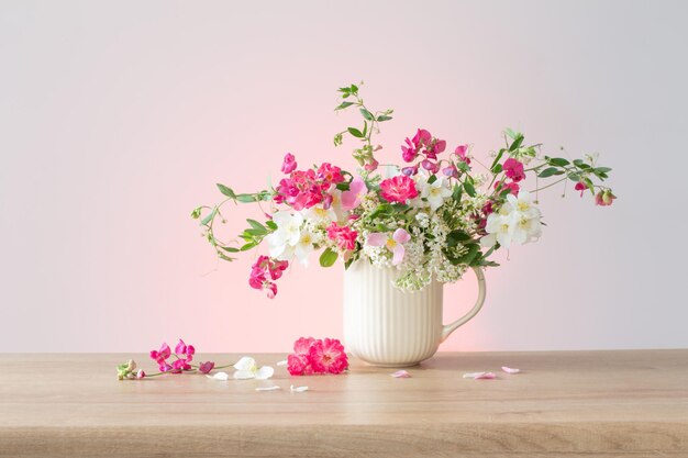 Foto flores de verão em copo de cerâmica na luz de fundo