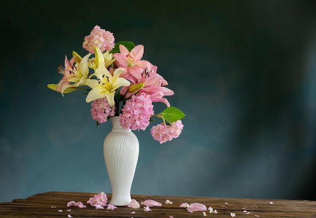 Flores de verão em vaso vintage branco em fundo escuro