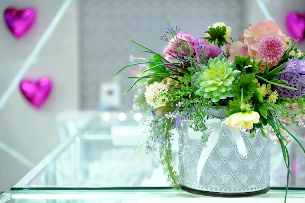 Flores decorativas en un hermoso jarrón en la ventana de una joyería