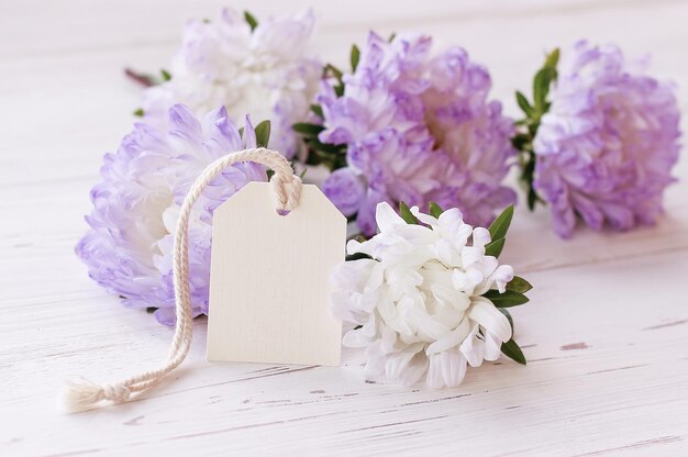 Flores delicadas y etiqueta simulada sobre un fondo blanco Lugar para texto Tarjeta de felicitación