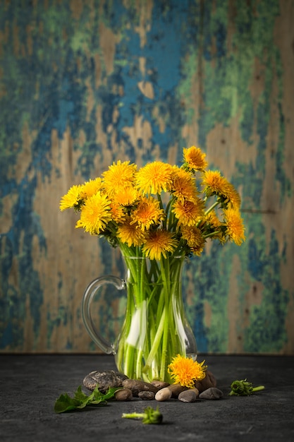 Flores de diente de León sobre fondo rústico.