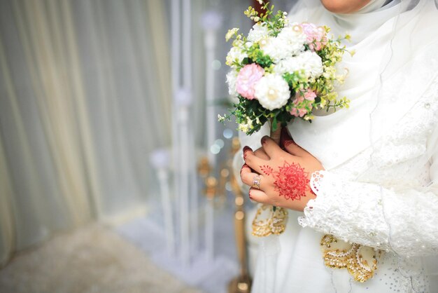 Flores do casamento Mulher segurando o buquê vermelho com as mãos no dia do casamento Foco seletivo