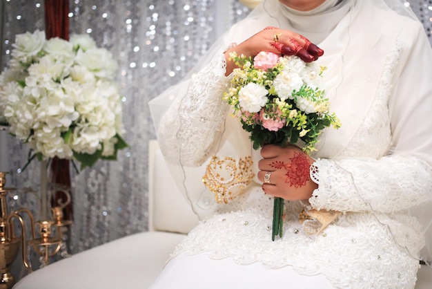 Flores do casamento Mulher segurando o buquê vermelho com as mãos no dia do casamento Foco seletivo