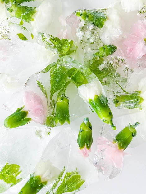 Foto flores do jardim de cravos congeladas em fundo de gelo