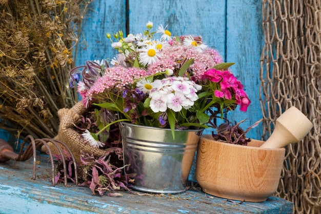 Flores do jardim em balde e argamassa com ervas curativas