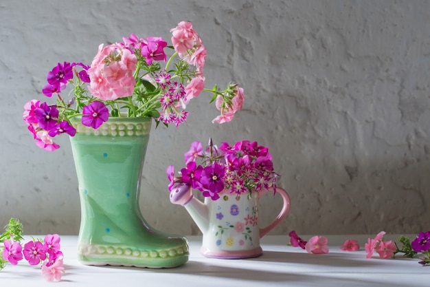 Flores do verão na bota cerâmica no branco