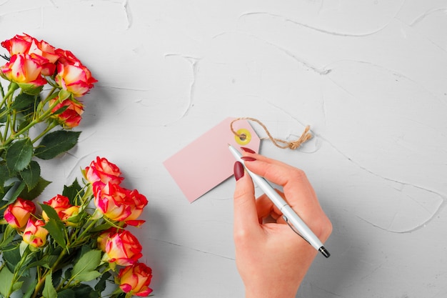 Flores e etiqueta de papel em branco. Enviando flores