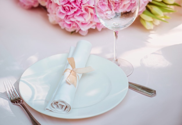 Flores e faca de garfo de placa de vidro na mesa conceito de almoço de comida de talheres