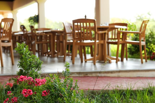 Foto flores e mesas e cadeiras embaçadas do lado de fora do terraço do restaurante