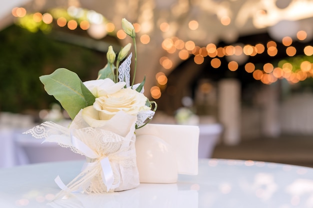 Flores em cima da mesa no restaurante ao ar livre. interior de um terraço de verão do café. cenário de mesa para recepção de casamento ou um evento. copie o espaço para texto.