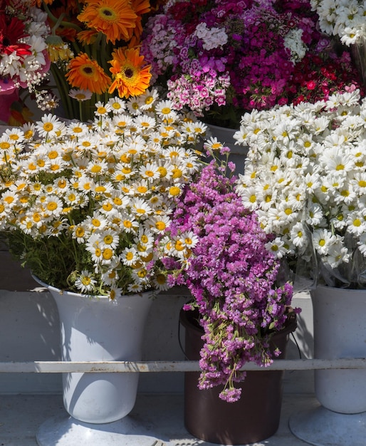 Flores frescas y coloridas puestas en jarrones en las floristerías