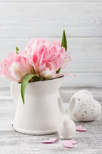 Flores frescas en jarra y huevos de Pascua