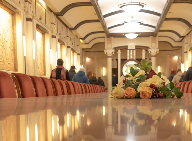 Flores frescas lindamente arranjadas na mesa com vista traseira das pessoas ao fundo