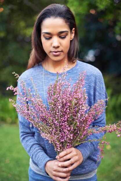 Flores frescas para o lar Uma jovem segurando um buquê de flores em um jardim