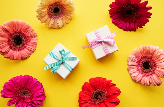 Flores de gerbera y cajas de regalo en amarillo.