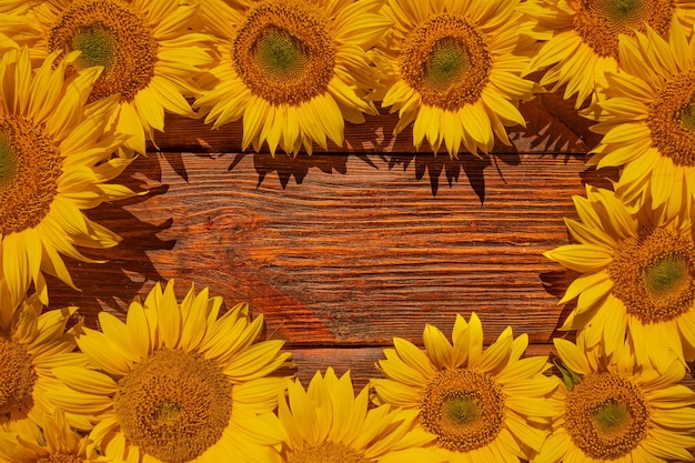 Flores de girasol brillantes en una vieja mesa de madera Vista desde arriba