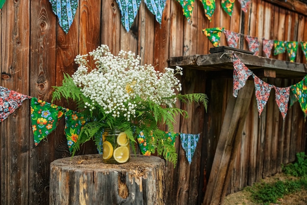 Flores de Gypsophila con rodajas de naranja sobre fondo de cobertizo de madera con banderas