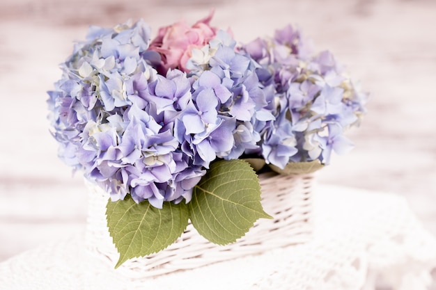 Flores de hortensias azules en la canasta blanca. Decoración floral para el hogar.