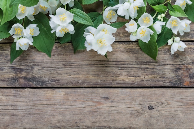 Flores de jazmín blanco sobre una mesa de madera