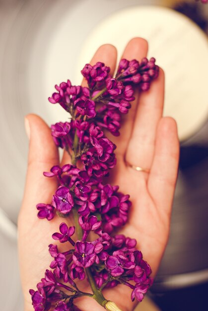 Flores lilas en mano.