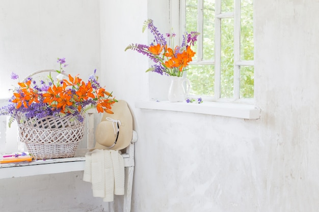 Flores de lirio y lupino en interior blanco vintage