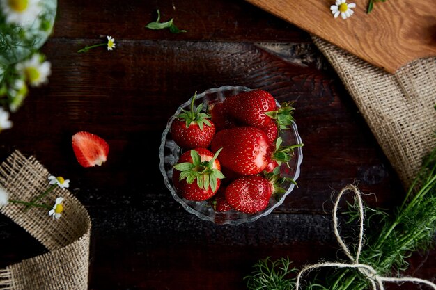 Flores de manzanilla de verano fresas frescas té natural y menta en saqueo en mesa de madera Estética estilo de vida femenino de verano Comida hermosa