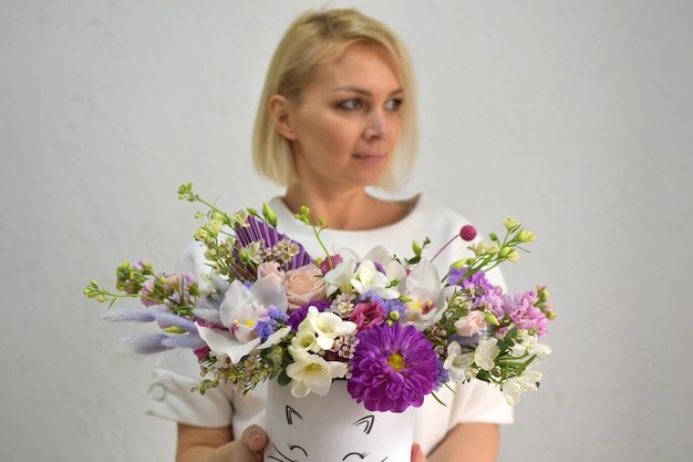 Flores na caixa de chapéu mulher com um buquê de flores catálogo on-line da composição da planta da loja de entrega de flores