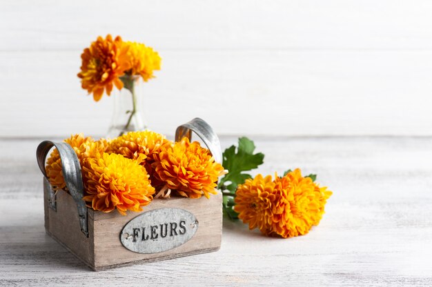 Flores naranjas en caja sobre mesa rústica