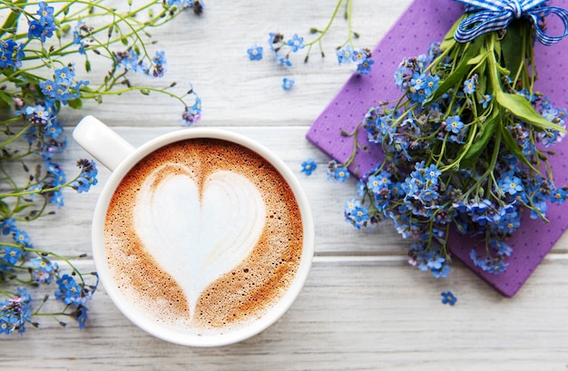 Flores nomeolvides, café y cuaderno