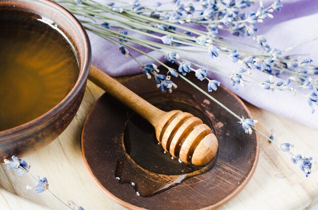 Flores orgânicas do mel e da alfazema na tabela de madeira.