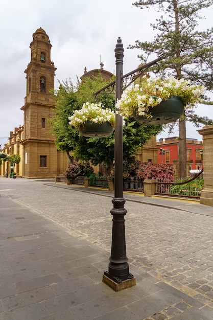 Flores penduradas em cestos em uma rua da cidade de galdar, na gran canária. europa,