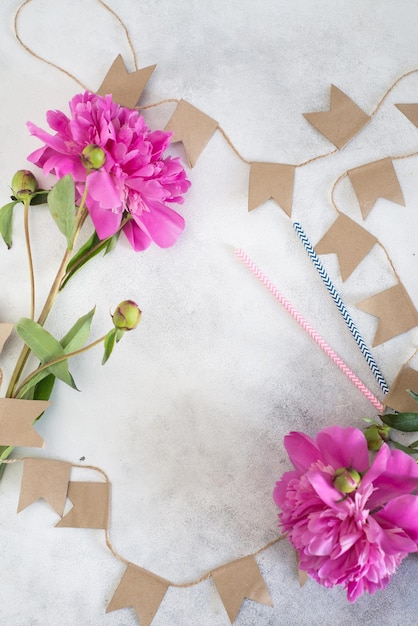 Flores de peonía con banderas en un fondo gris con espacio vacío para texto