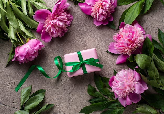 Flores de peonía rosa y caja de regalo.