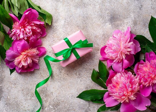 Flores de peonía rosa y caja de regalo.