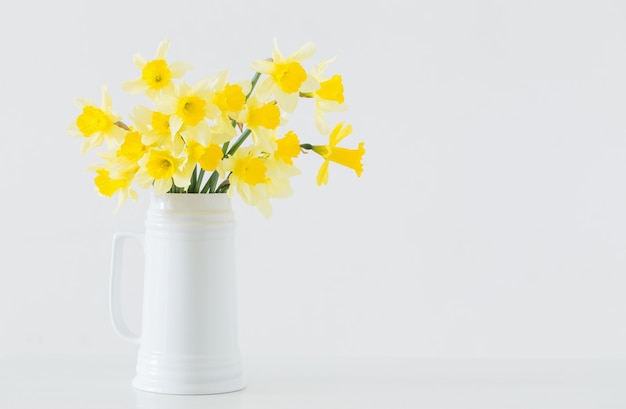 Flores de primavera amarilla sobre superficie blanca