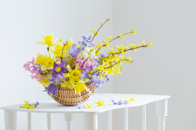 Flores de primavera en cesta en interior blanco