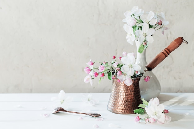 Flores de primavera en cezve en mesa blanca