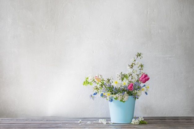 Flores de primavera en cubo azul