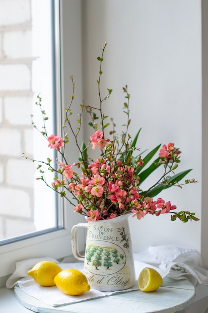 Flores de primavera en florero con limones