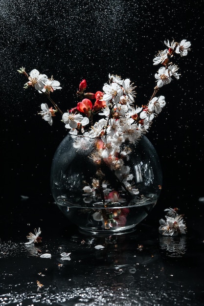 Flores de primavera en un jarrón sobre un fondo oscuro gotas de lluvia